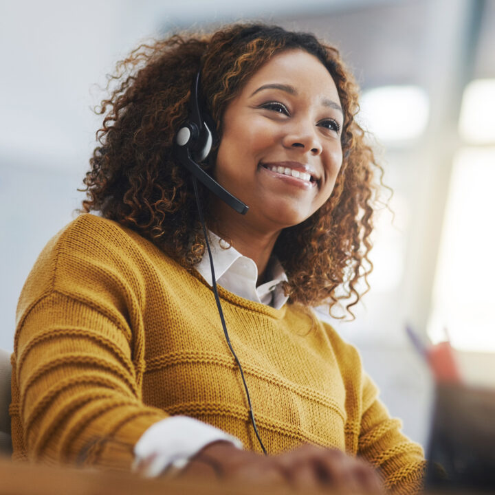 Woman on a headset at a call center smiling